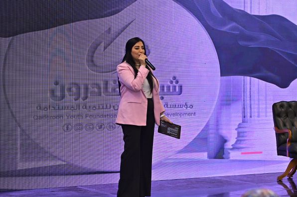 مقدّم على المسرح أمام خلفية شباب قادرون